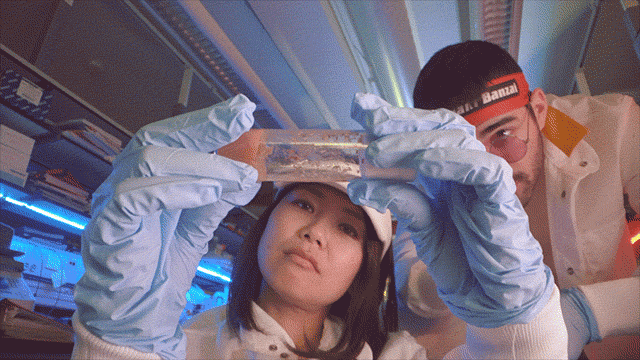 Azumi and Cole inspect a test tube in Confabulations